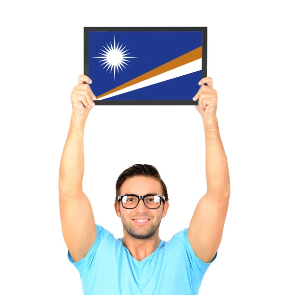 Portrait of a young casual man holding up board with National fl — Stock Photo, Image