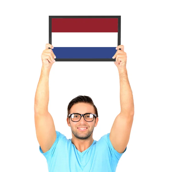 Portrait of a young casual man holding up board with National fl — Stock Photo, Image