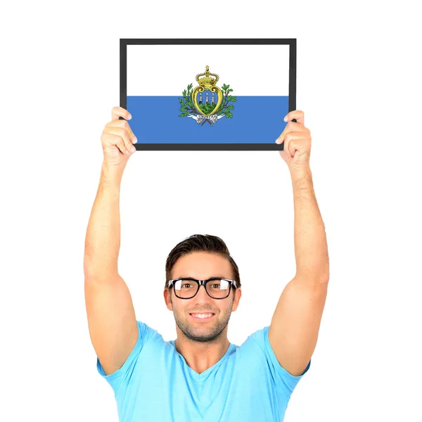 Portrait of a young casual man holding up board with National fl — Stock Photo, Image