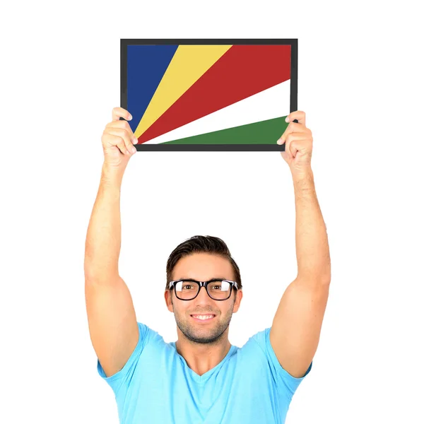 Portrét mladého muže příležitostné drží desku s národním fl — Stock fotografie