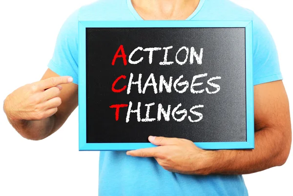 Man holding blackboard in hands and pointing the word ACTION CHA — Stock Photo, Image