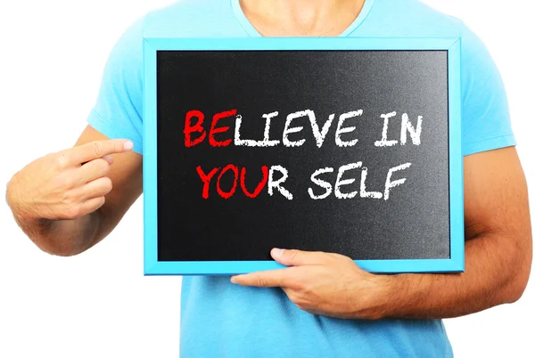 Man holding blackboard in hands and pointing the word BELIEVE IN — Stock Photo, Image