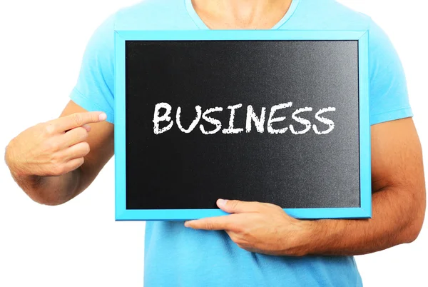 Человек, держащий доску в руках и указывающий на слово BUSINESS — стоковое фото