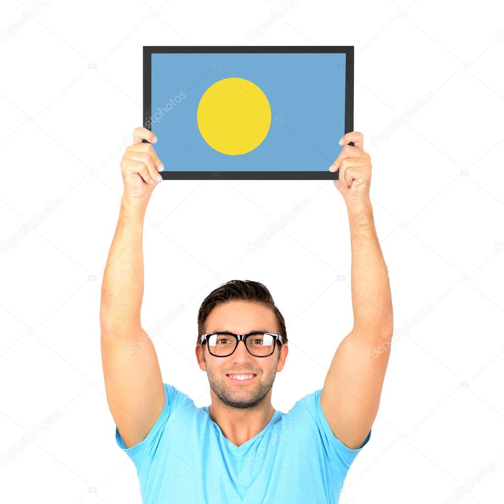 Portrait of a young casual man holding up board with National fl