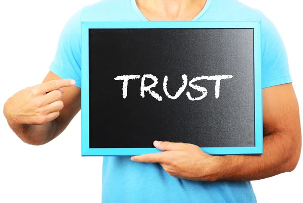 Man holding blackboard in hands and pointing the word TRUST — Stock Photo, Image