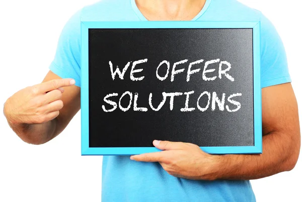 Man holding blackboard in hands and pointing the word WE OFFER S — Stock Photo, Image