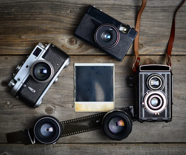 Fotocamera vintage con lenti e vecchia fotografia vuota su ba di legno — Foto Stock