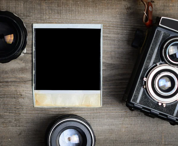 Vintage camera with lenses and blank old photograph on wooden ba — Stock Photo, Image