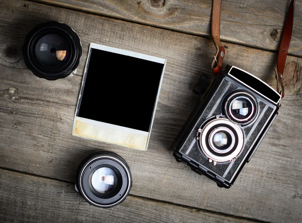 Vintage fotoğraf makinesi ile lensler ve boş eski fotoğraf üzerinde ahşap ba — Stok fotoğraf