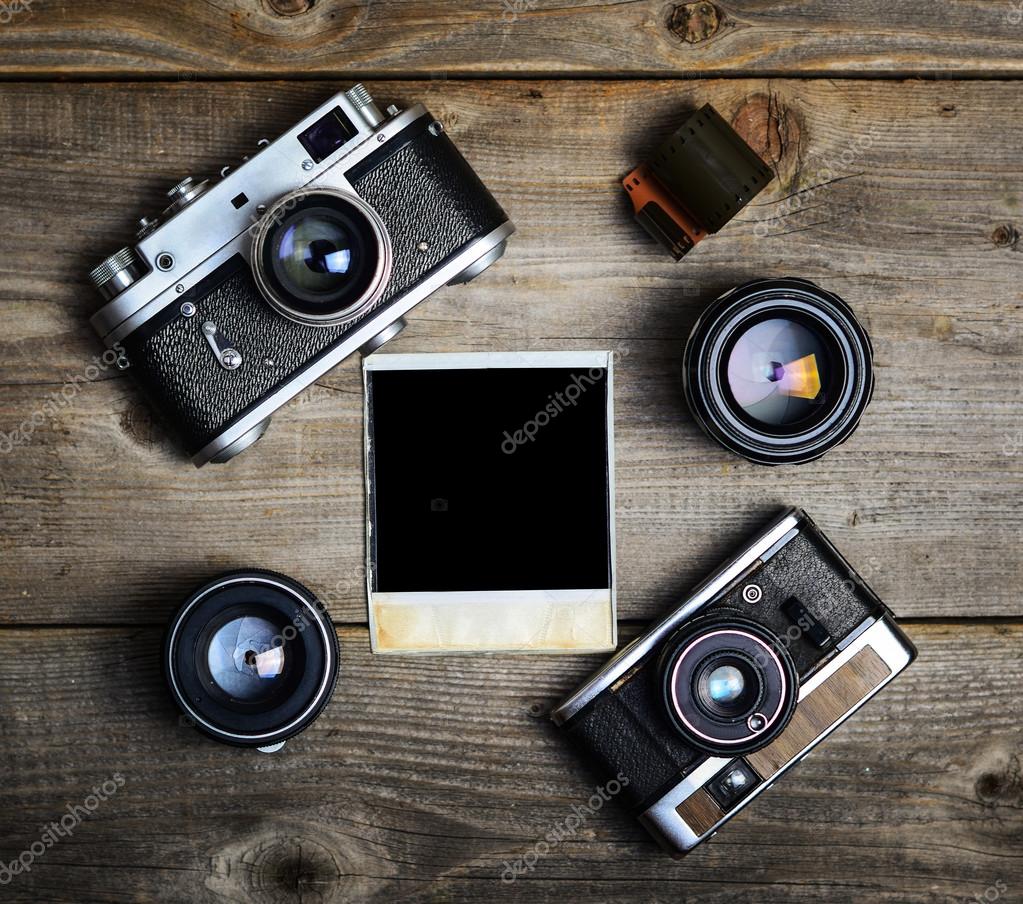 hoogte genezen Consumeren Vintage cameras with lenses and blank old photograph on wooden b Stock Photo  by ©Alexis84 55781279