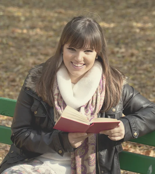 Student meisje het lezen van boek op Bank in herfst bos — Stockfoto