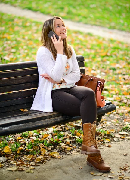 Mujer joven y feliz hablando por teléfono en Autumn Park — Foto de Stock