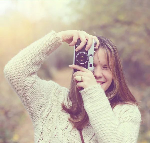 Дівчина з старовинною камерою робить фото на відкритому повітрі — стокове фото