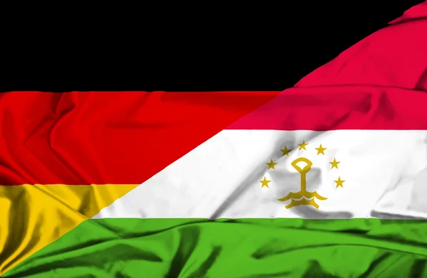 Bandeira ondulada do Tajiquistão e da Alemanha — Fotografia de Stock