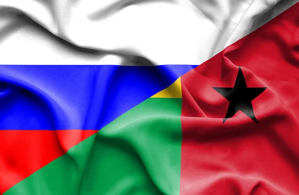 Waving flag of Guinea Bissau and Russia — Stock Photo, Image