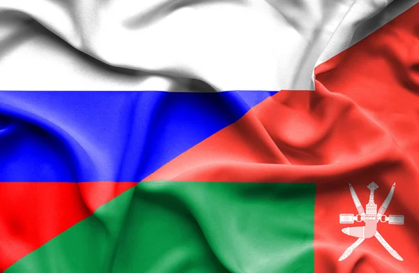 Waving flag of Oman and Russia — Stock Photo, Image