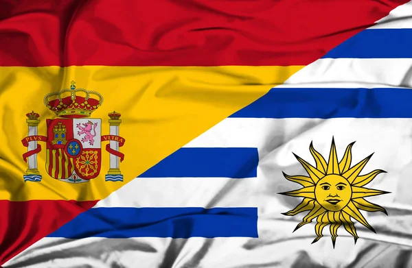 Waving flag of Uruguay and Spain — Stock Photo, Image