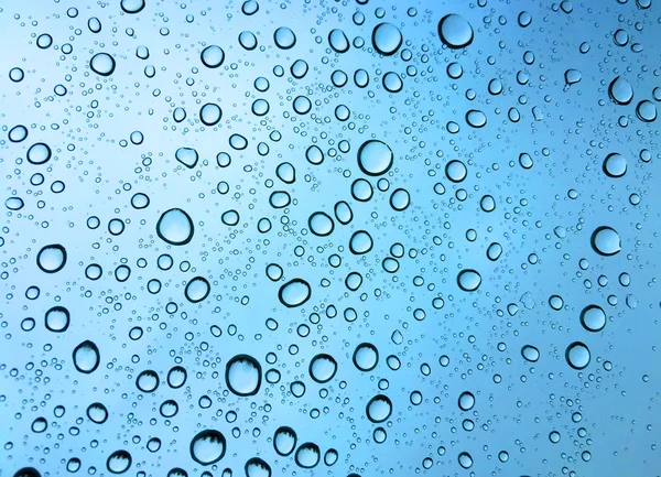 Wasser fällt auf blauen Hintergrund — Stockfoto
