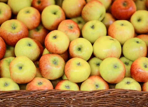 Fresh apples in wicker basket at open fruit market — Stock Photo, Image