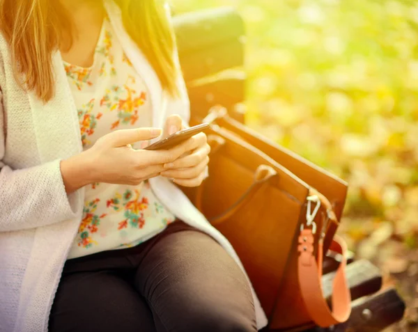 Woman using mobile smart phone in the park — Stock Photo, Image