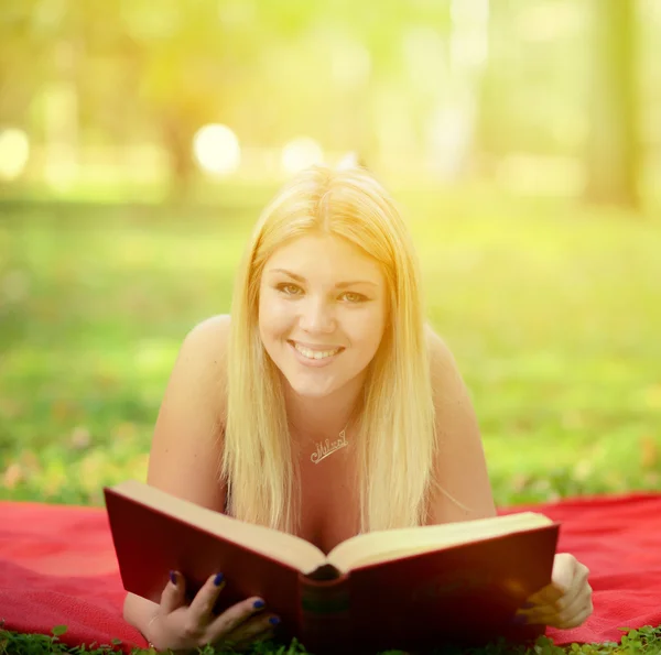 Happy smiling woman reading book in park — Stock Photo, Image