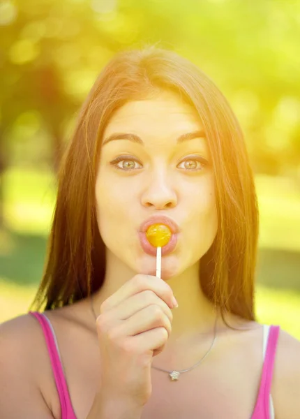 Funny portrait of girl licking lollipop — Stock Photo, Image