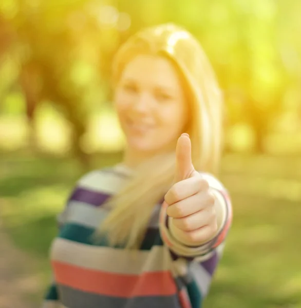 Portrait of girl holding thumb up with focus on thumb — Stock Photo, Image