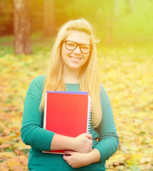 Belle étudiante blonde souriante tenant des livres — Photo