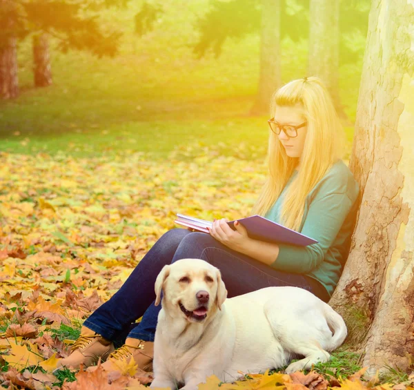 Dziewczyna uczniów uczenia się w przyrodzie z psem — Zdjęcie stockowe