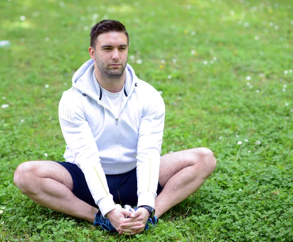 Schöner Sportler dehnt sich im Freien — Stockfoto