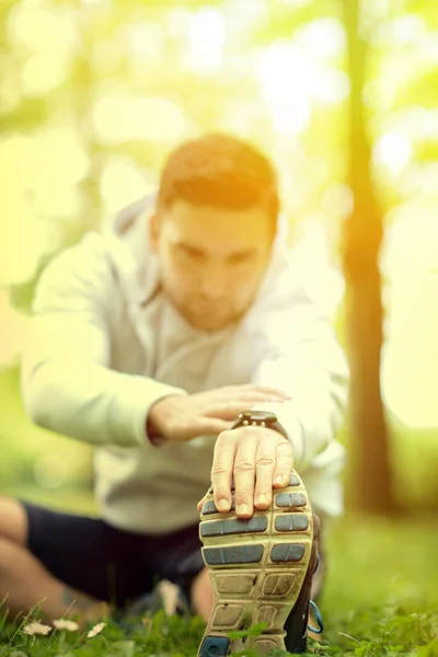 Handsome sportsman stretching outdoors — Stock Photo, Image