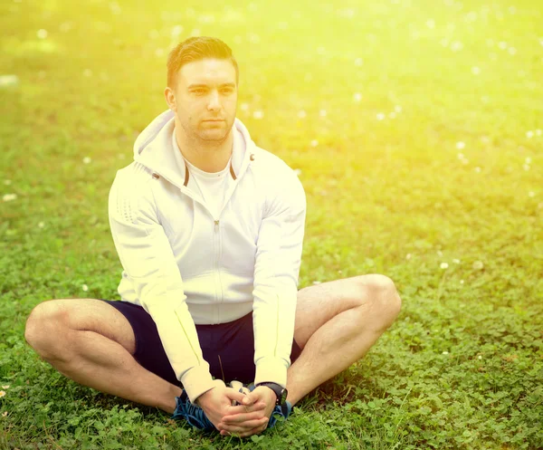 Schöner Sportler dehnt sich im Freien — Stockfoto