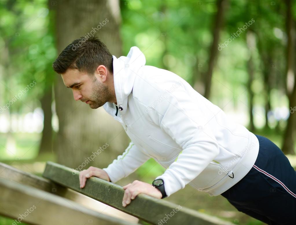 Male athlete exercising push up outside