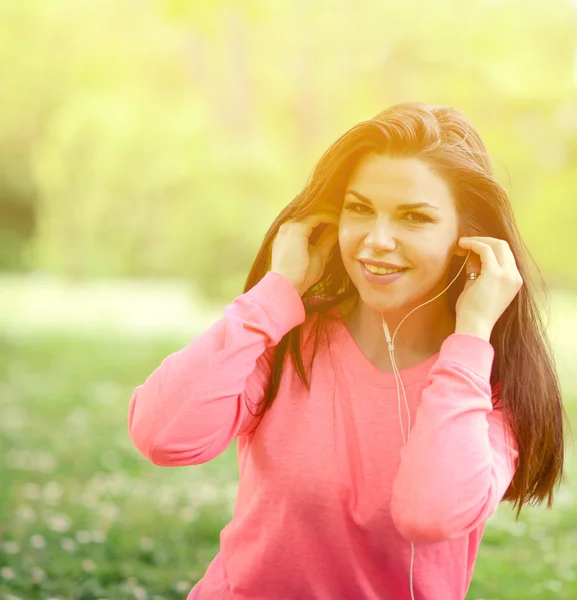 Vrouwelijke student meisje buiten in park luisteren naar muziek op headph — Stockfoto