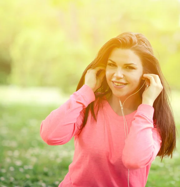 Mujer estudiante fuera en parque escuchando música en headph —  Fotos de Stock