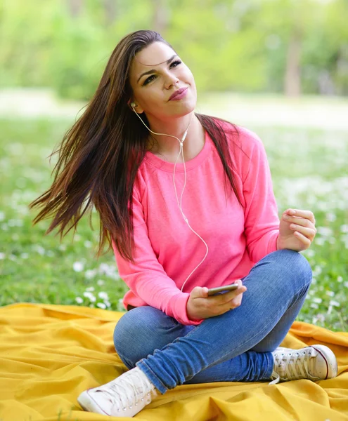 Mujer estudiante fuera en parque escuchando música en headph —  Fotos de Stock