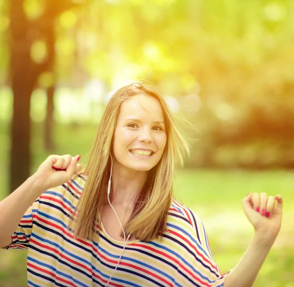 Female student girl outside in park listening to music on headph — Stock Photo, Image