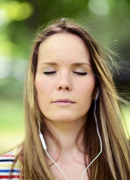 Mujer estudiante fuera en parque escuchando música en headph —  Fotos de Stock