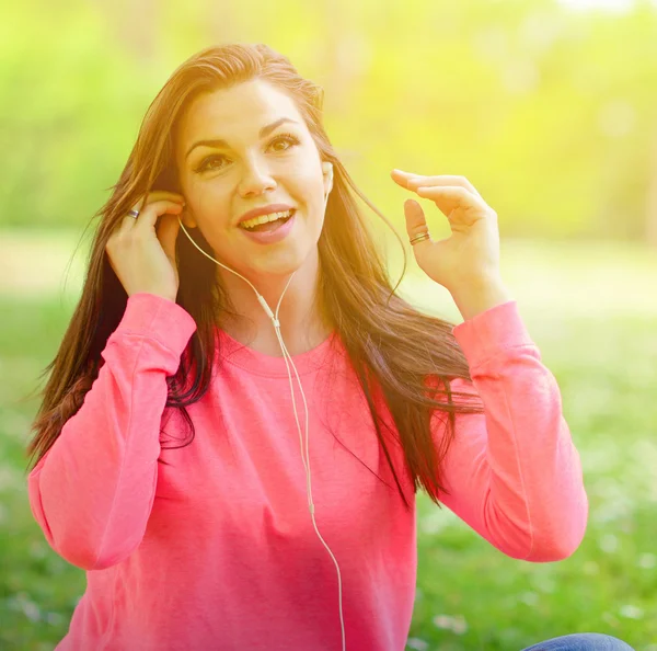 Vrouwelijke student meisje buiten in park luisteren naar muziek op headph — Stockfoto