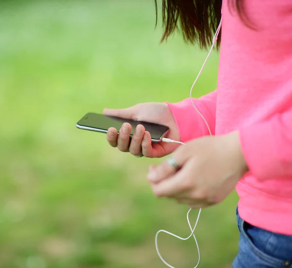 10 代の少女のクローズ アップ手携帯電話を屋外で使う — ストック写真