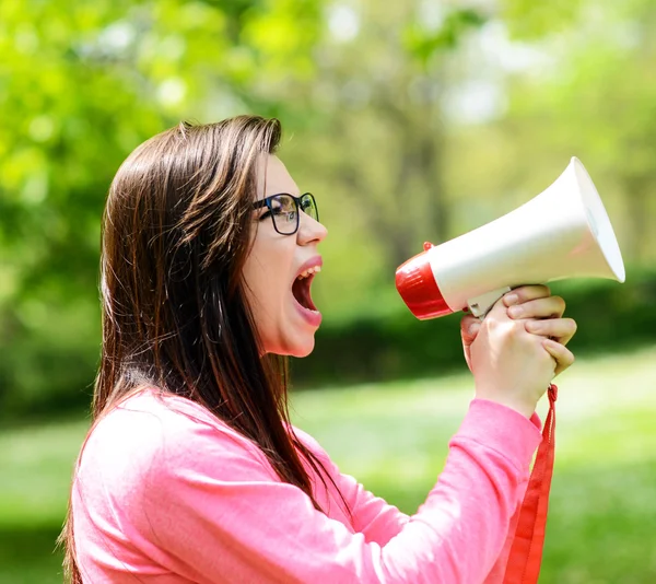 Porträt einer Frau mittleren Alters, die mit einem Megafon gegen eine — Stockfoto