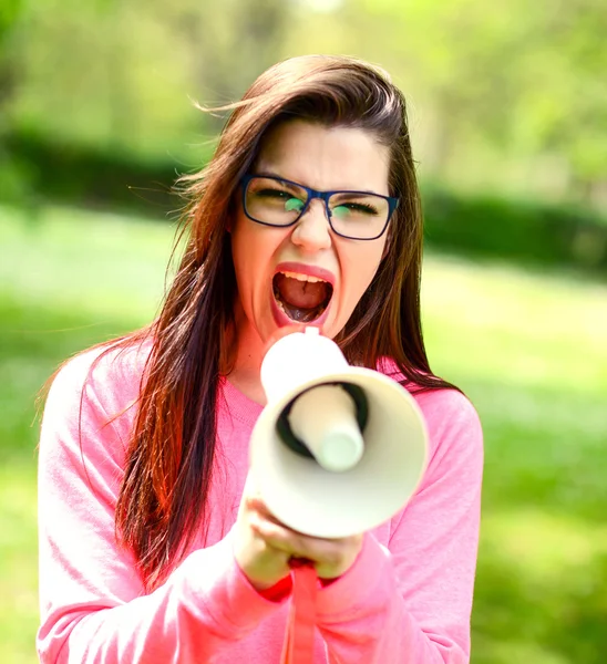 Porträt einer Frau mittleren Alters, die mit einem Megafon gegen eine — Stockfoto