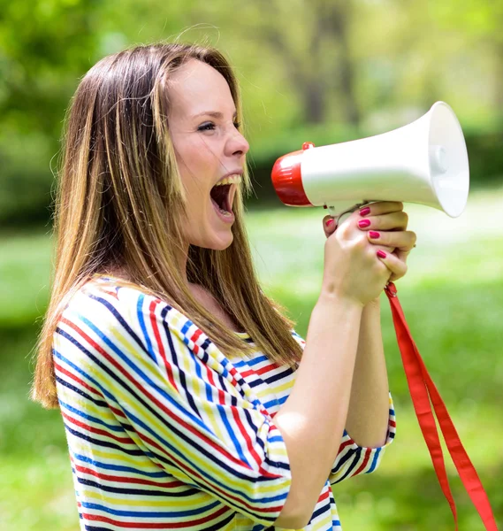 Porträt einer Frau mittleren Alters, die mit einem Megafon gegen eine — Stockfoto