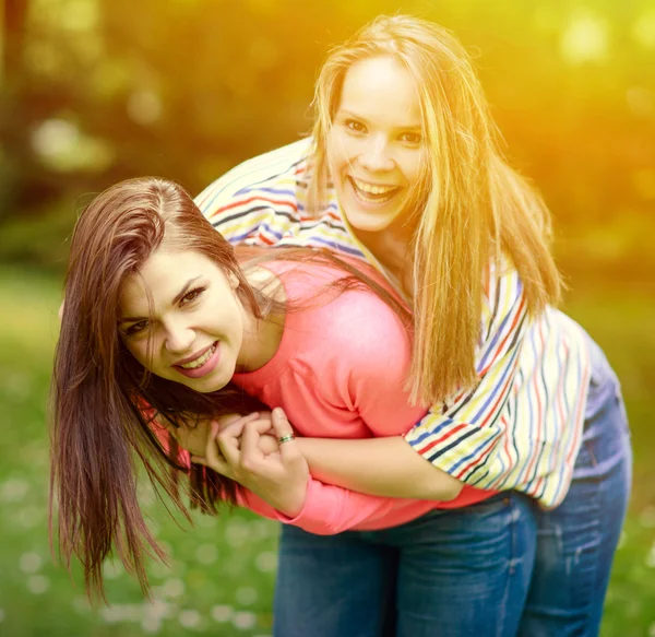 Two young girl friends in a hug at park — Stock Photo, Image