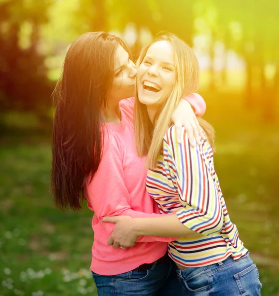 Two young girl friends in a hug at park — Stock Photo, Image