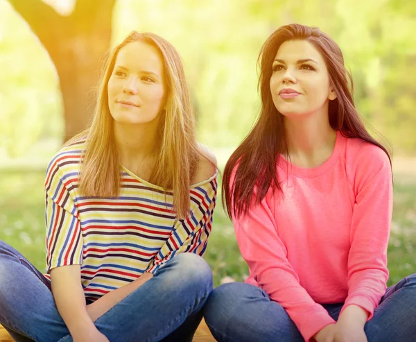 Две девушки сидят на траве в летний день — стоковое фото