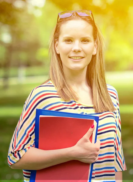 Ung glad student kvinna med boken i händerna ständiga — Stockfoto