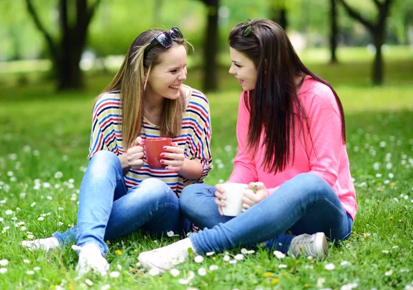 Young women drinking coffee at park and enjoying summer day — Stock Photo, Image