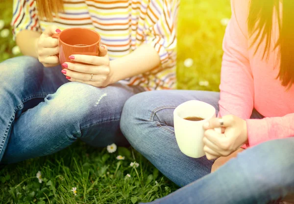Jonge vrouwen drinken koffie in het park en genieten van de zomerdag — Stockfoto