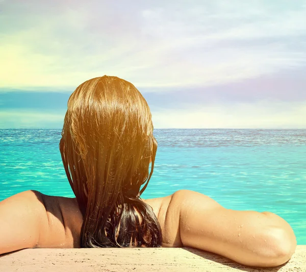 Mavi su içinde rahat kadın arkadan görünüm — Stok fotoğraf